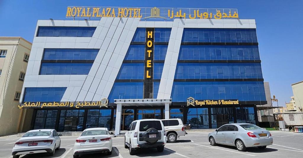 a building with cars parked in front of it at Royal Plaza Hotel in Duqm