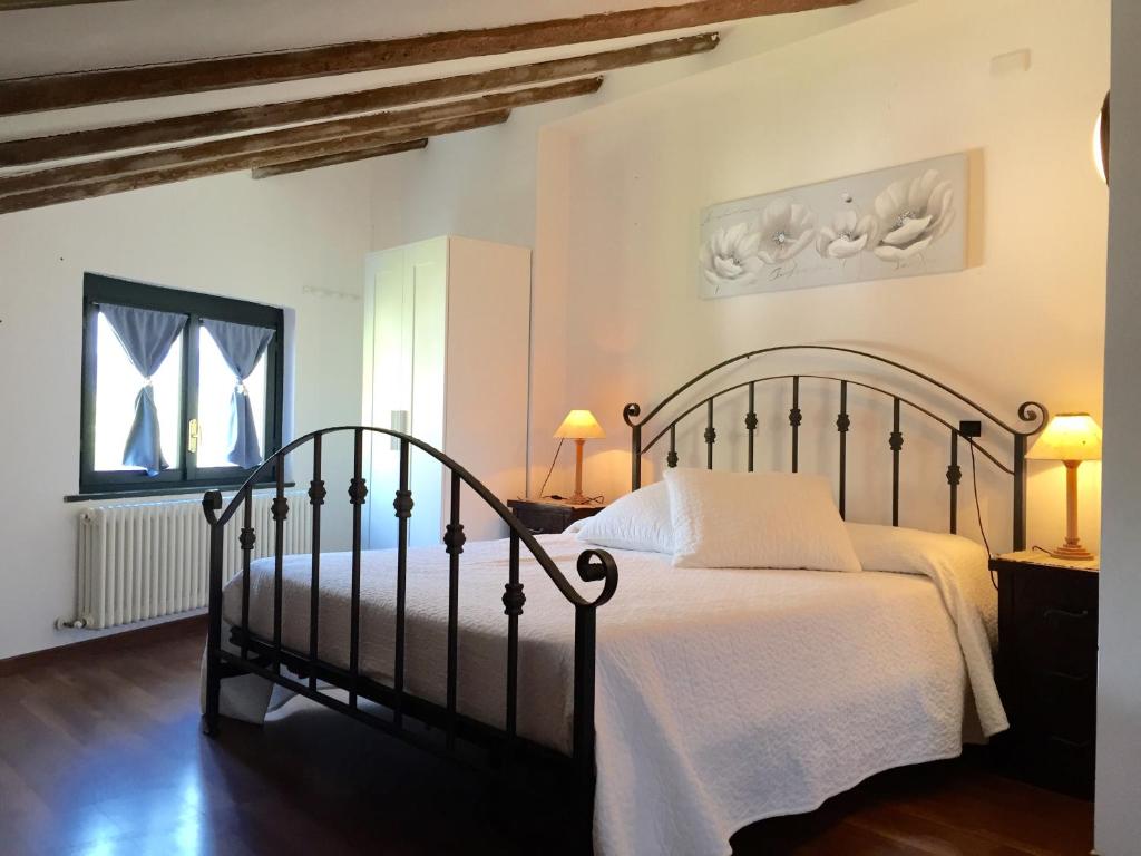sypialnia z czarnym łóżkiem z białą pościelą w obiekcie Hotel Villa San Fedele w mieście San Fedele Intelvi
