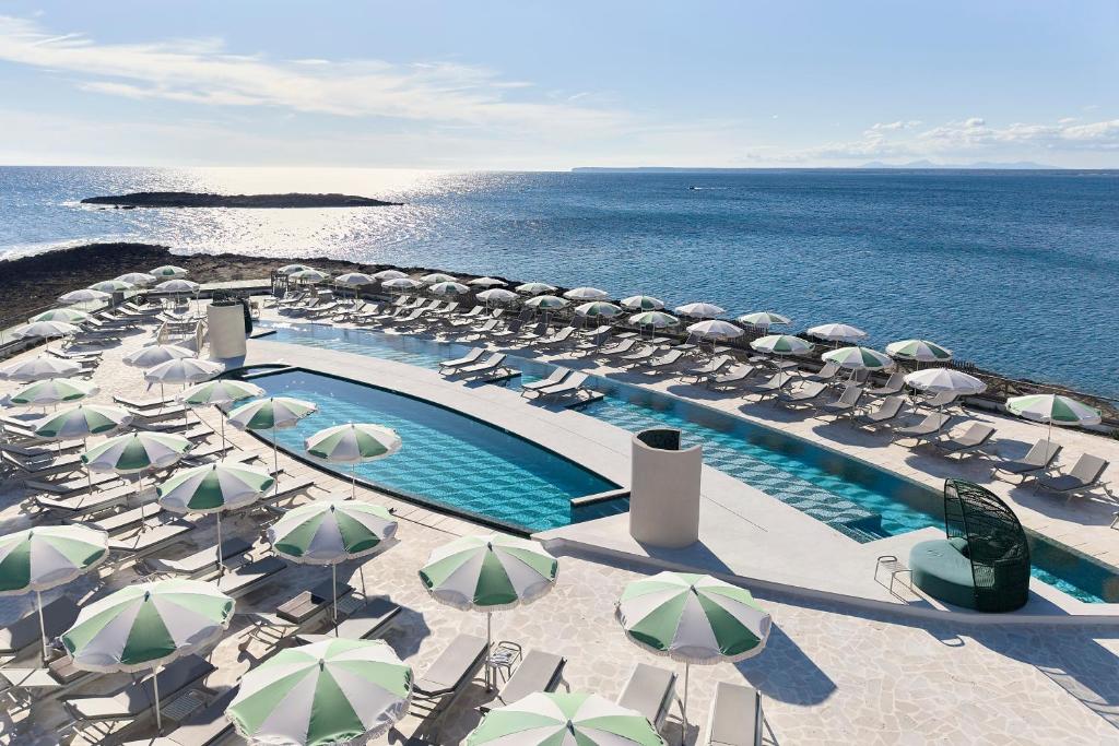 basen z parasolami i krzesłami oraz ocean w obiekcie Iberostar Selection Es Trenc -New Opening- w miejscowości Colonia Sant Jordi