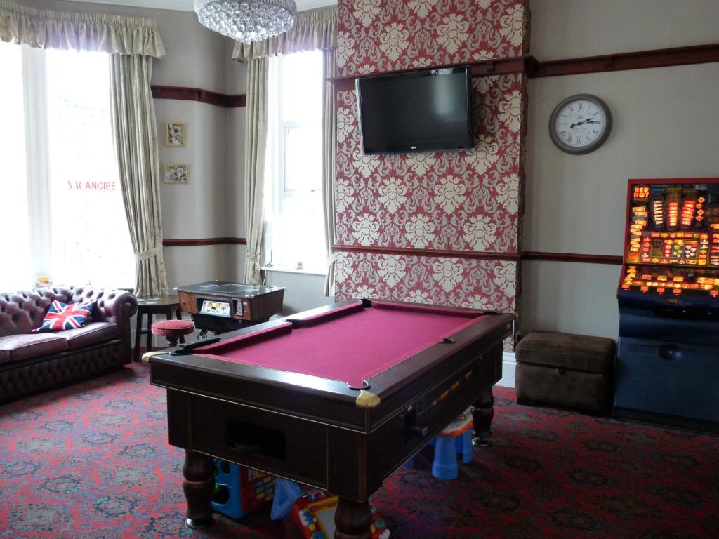 a living room with a pool table and a tv at Hilbre Hotel in Blackpool