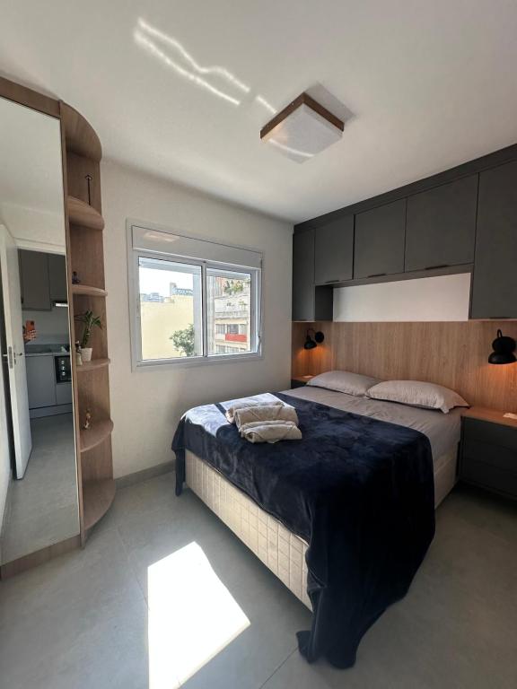 a bedroom with a large bed and a window at Apto Completo, 3min Estação Higienópolis Mackenzie Consolação in Sao Paulo