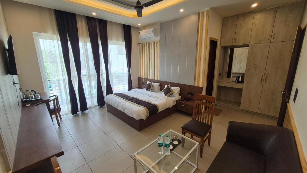 a bedroom with a bed and a table in a room at The Corbett Green Woods in Rāmnagar