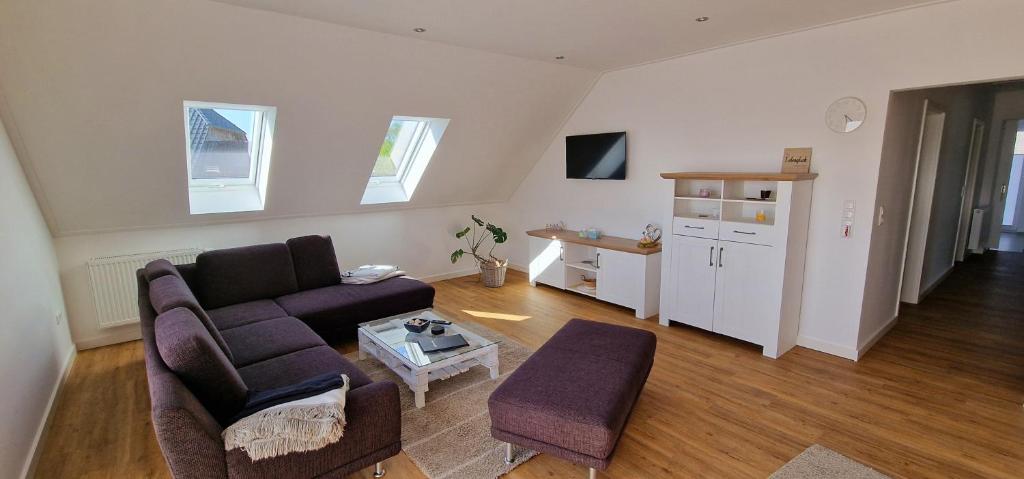 a living room with a couch and a table at Ferienhaus Strandallee 10a in Burhave