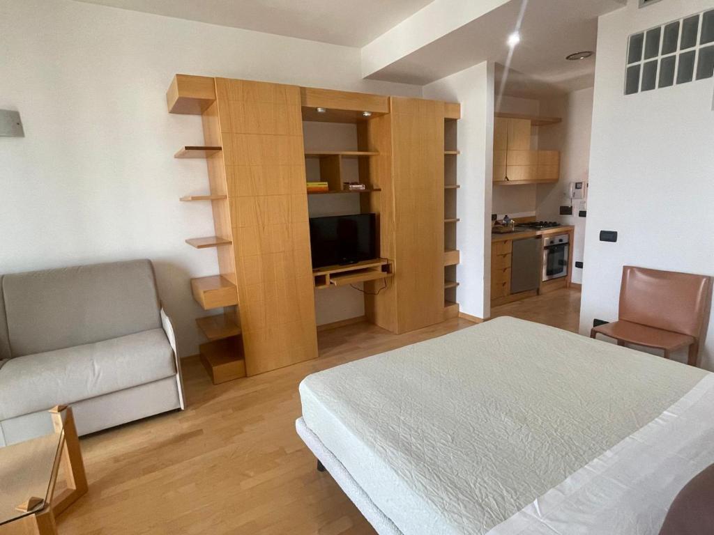 a bedroom with a bed and a couch and a television at garibaldi citta' in Trapani