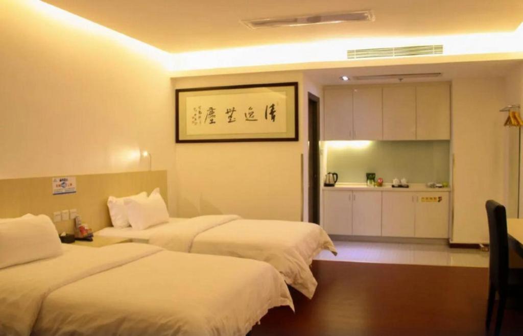 a hotel room with two beds and a kitchen at Guangzhou Hailian Hotel - Haizhu District Binjiang East Road Metro Station in Guangzhou