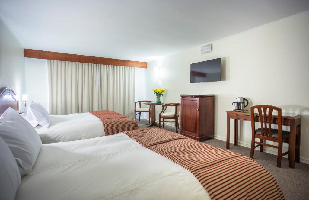 Postel nebo postele na pokoji v ubytování MR Hotel Providencia (ex Hotel Neruda)