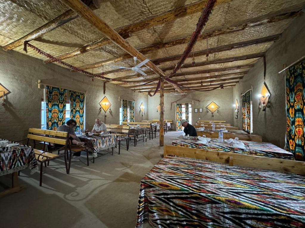 a room with people sitting at tables in a building at GOLDEN Safari YURT CAMP in Elʼtay