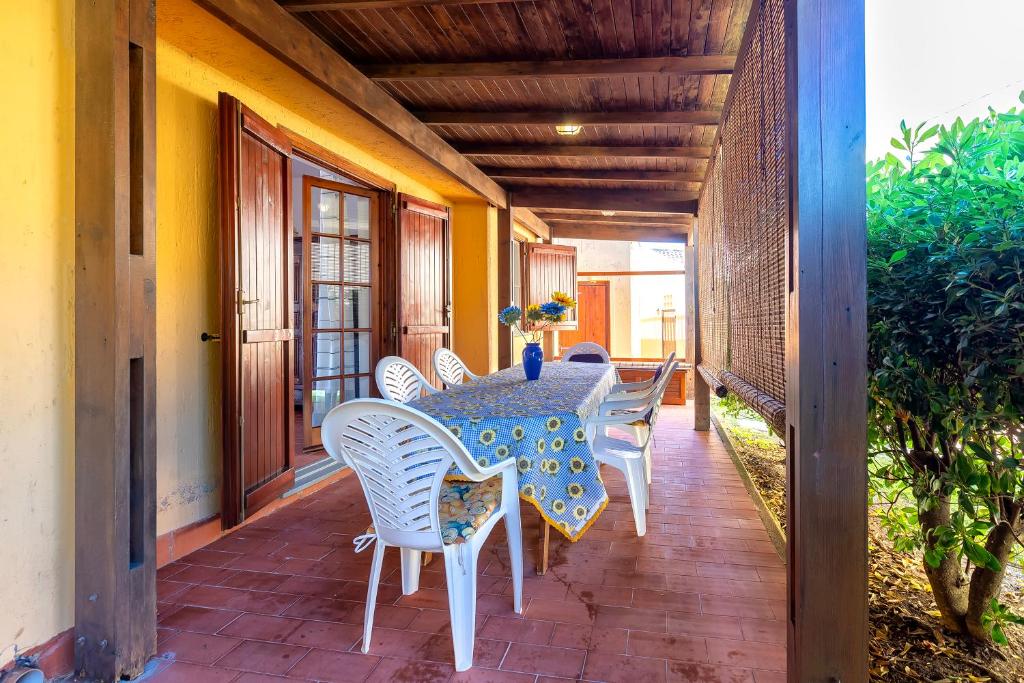 a patio with a table and chairs on a porch at Casa Claudia Le Tonnare Stintino in Stintino