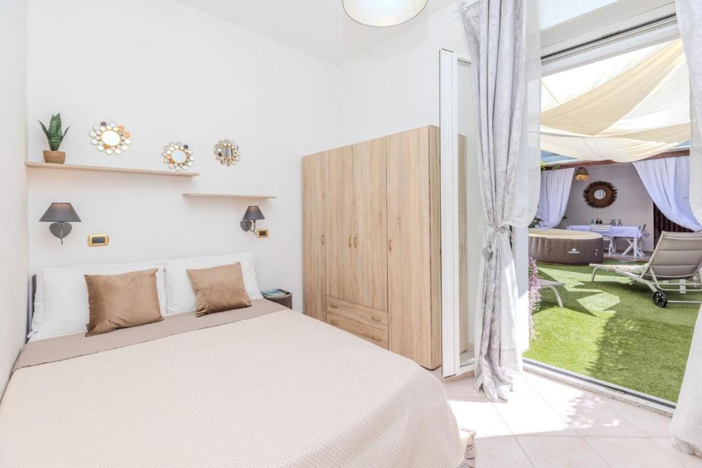 a bedroom with a bed and a large window at Maria House, Jacuzzi e Patio in Olbia