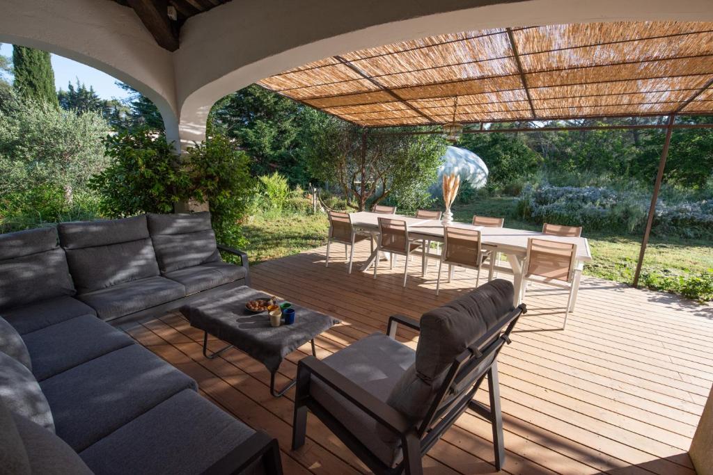 un patio avec un canapé, une table et des chaises dans l'établissement Villa Le Blavet, à Puget-sur Argens