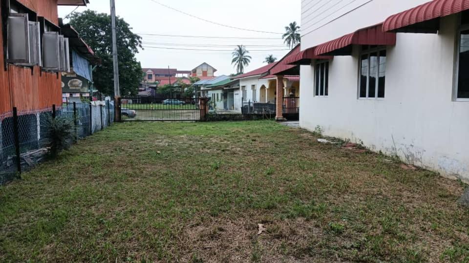 an empty yard between two houses withgrass at Guest house sri purnama banggol in Kota Bharu