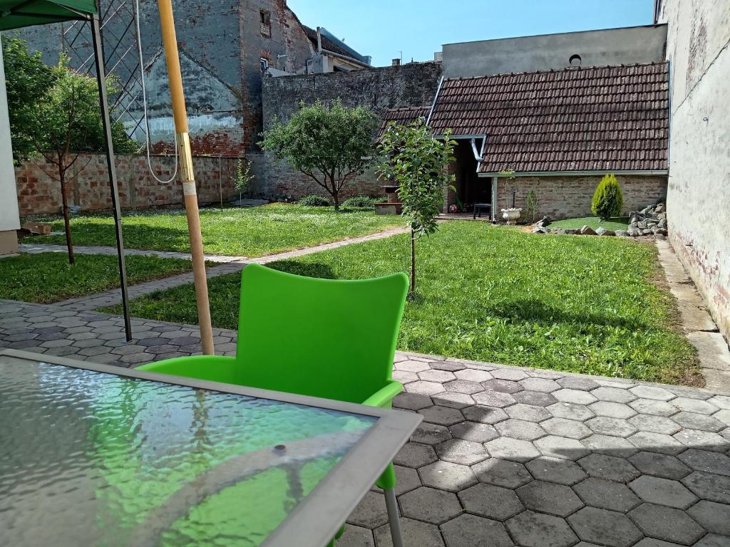 a green chair sitting next to a glass table at Apartments Košević in Osijek