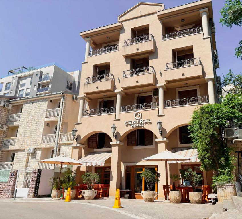a large building with umbrellas in front of it at Central Hotel & Restaurant in Budva