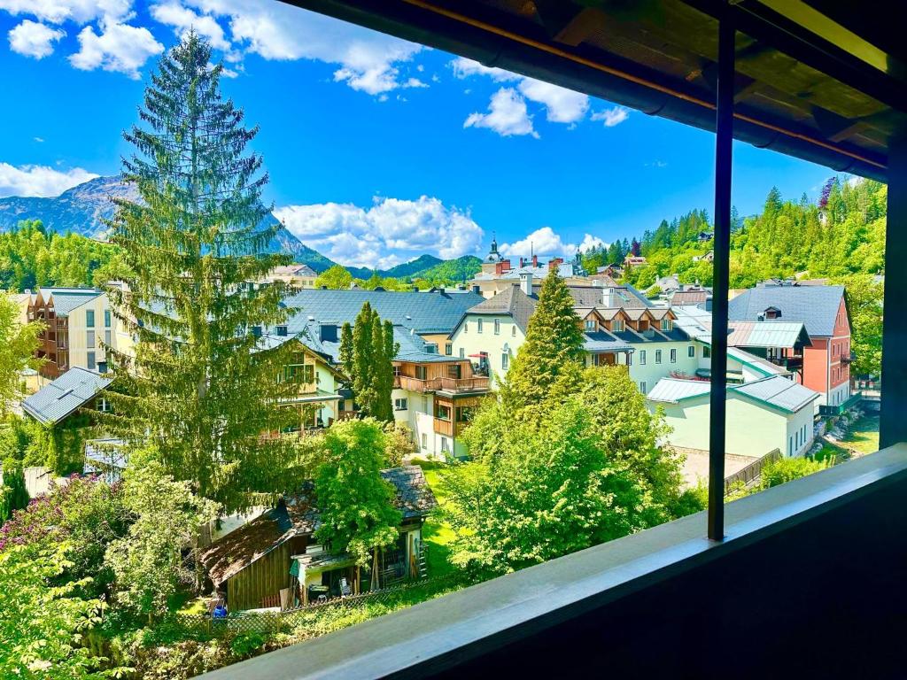 a view from a window of a town with trees and buildings at Miami Vice Appartement mit Balkon & Flussblick-Das Alpenzeit im Zentrum mit Parkplatz in Bad Aussee
