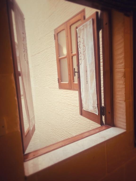 an open window of a house with a door at Narcisa Farmhouse B&B in Nadur