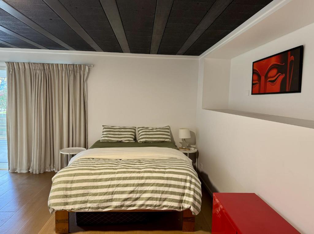1 dormitorio con cama y mesa roja en Wanaka Matai Studio, en Wanaka