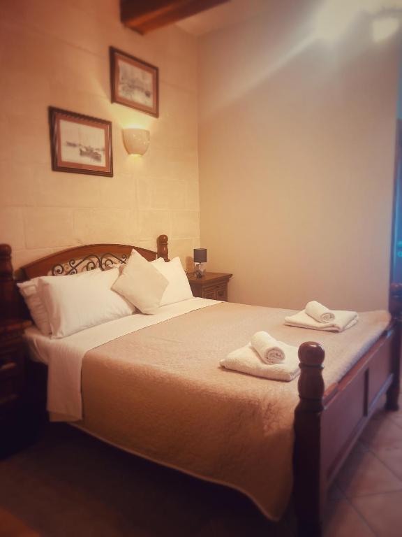 a bedroom with a bed with two towels on it at Narcisa Farmhouse B&B in Nadur
