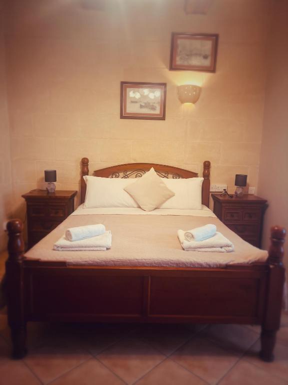 a bedroom with a bed with two towels on it at Narcisa Farmhouse B&B in Nadur