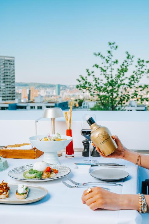 a table with plates of food and a bottle of wine at FIVE Zurich - Luxury City Resort in Zürich