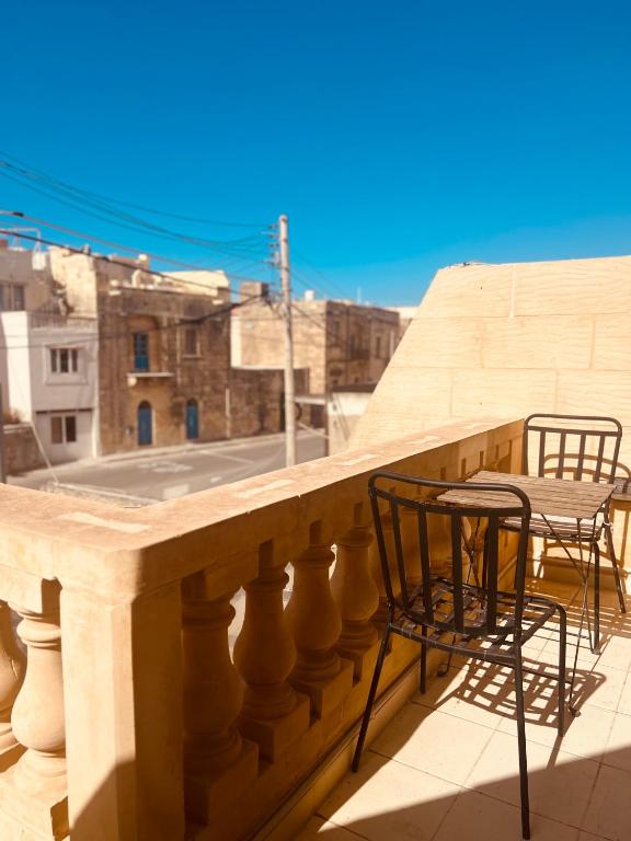 two chairs and a table on a balcony with a view at Narcisa Farmhouse B&B in Nadur