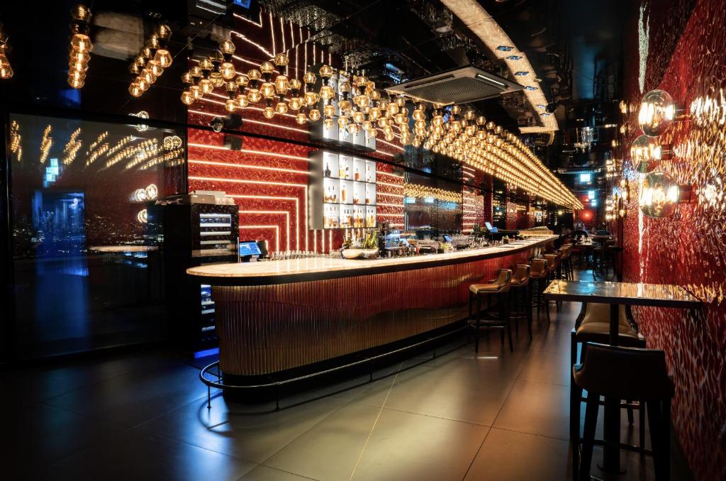a bar in a restaurant with tables and chairs at FIVE Zurich - Luxury City Resort in Zürich