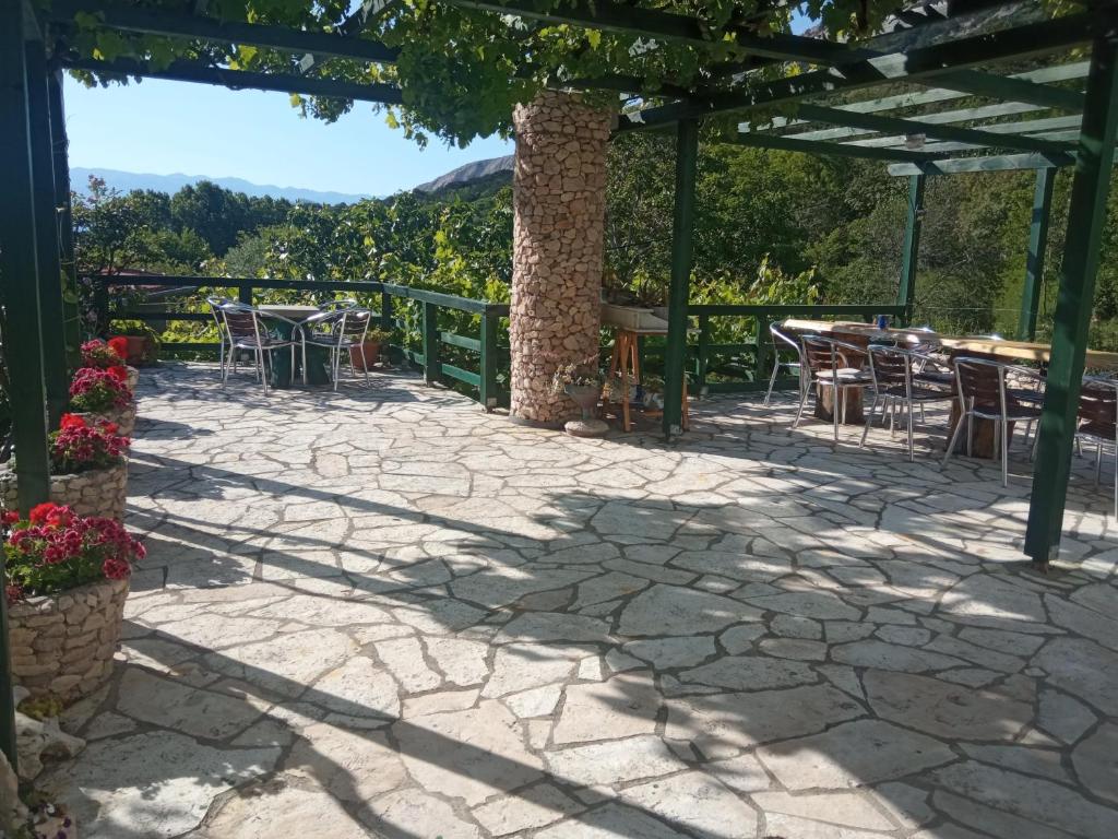 a patio with tables and chairs under a pergola at KATY&MLADEN in Baška
