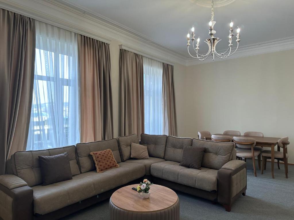 a living room with a couch and a table at Central ISr Baku apartment by Bakuapart in Oxut