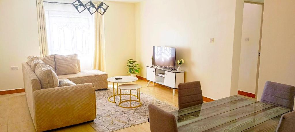 a living room with a couch and a tv at Cozy Escape in Ongata Rongai 