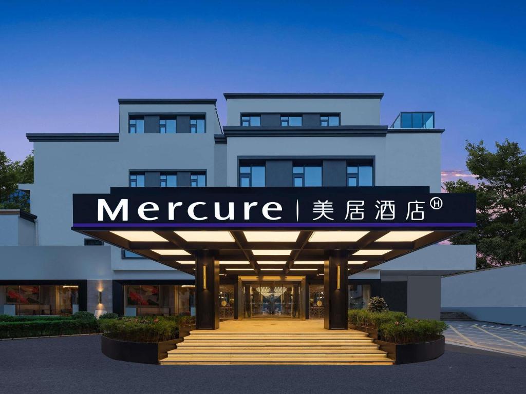 a building with a sign for a store at Mercure Xi'an Stadium Hotel in Xi'an