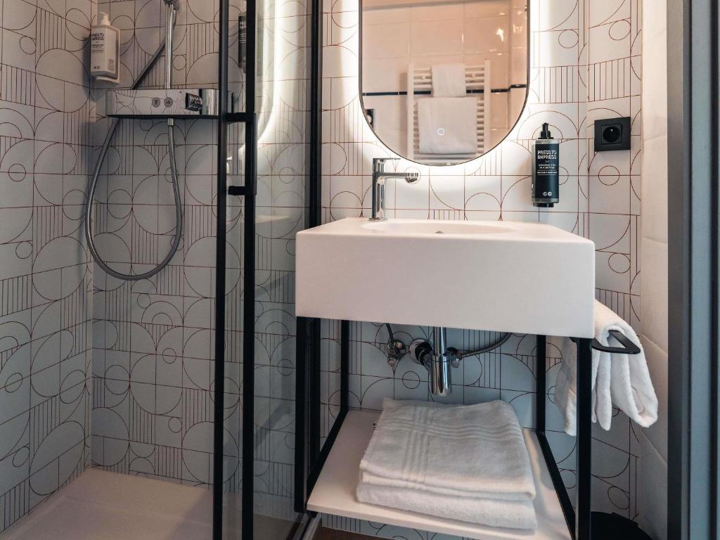 um banheiro com uma pia e um espelho em Ibis Styles Charleroi Airport Aero 44 em Charleroi
