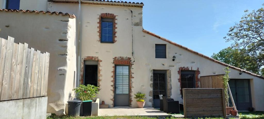 an old white building with windows and a fence at Chez Henri in Les Herbiers
