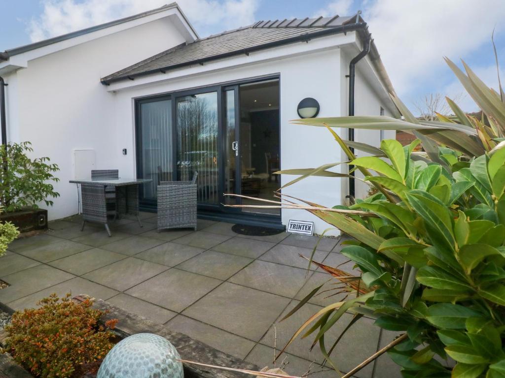 a white house with a patio with a table at The Annexe Trintex in Tenby