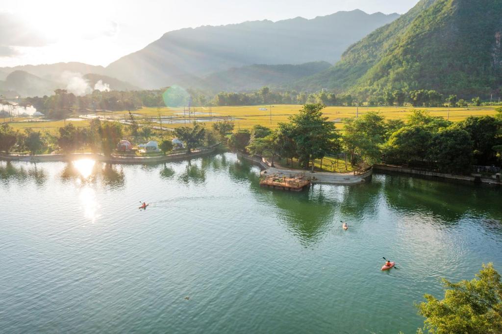 an aerial view of a river with people in boats at Mai Chau Lodge in Mai Châu