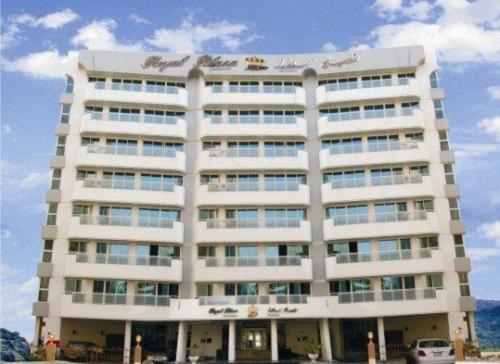 a large white building with a car parked in front of it at Royal Plaza Hotel Apartments in Dubai