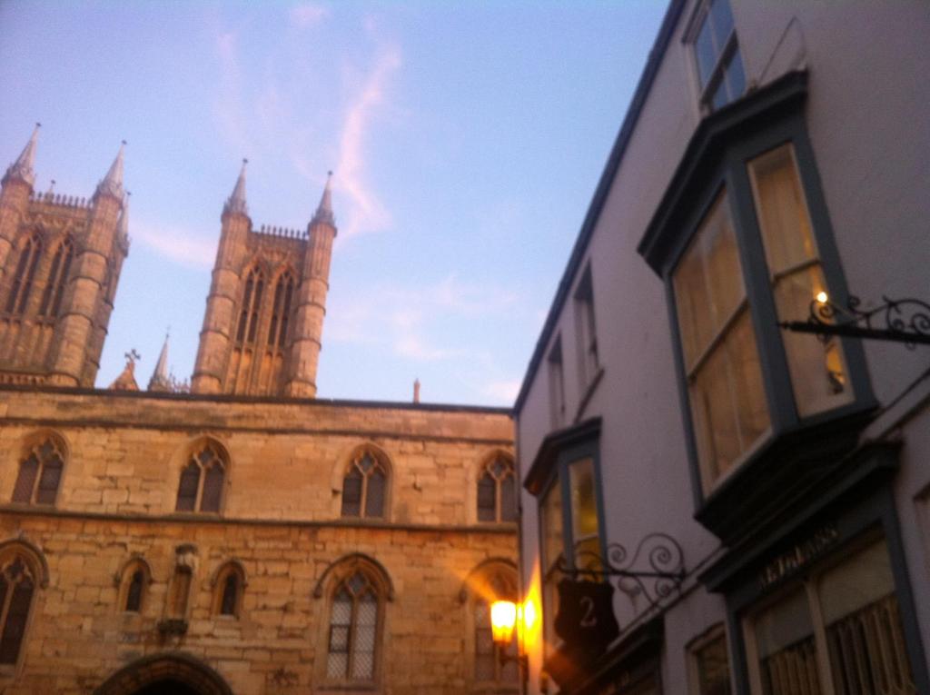 an old building with a cathedral in the background at Exchequergate in Lincoln