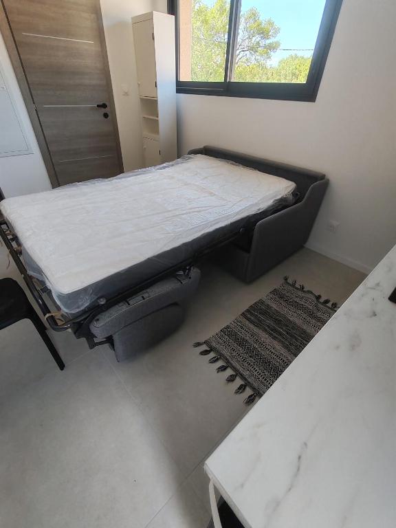 un lit d'hôpital dans une chambre avec fenêtre dans l'établissement Studio 2 pers entièrement équipé, à Prades-le-Lez