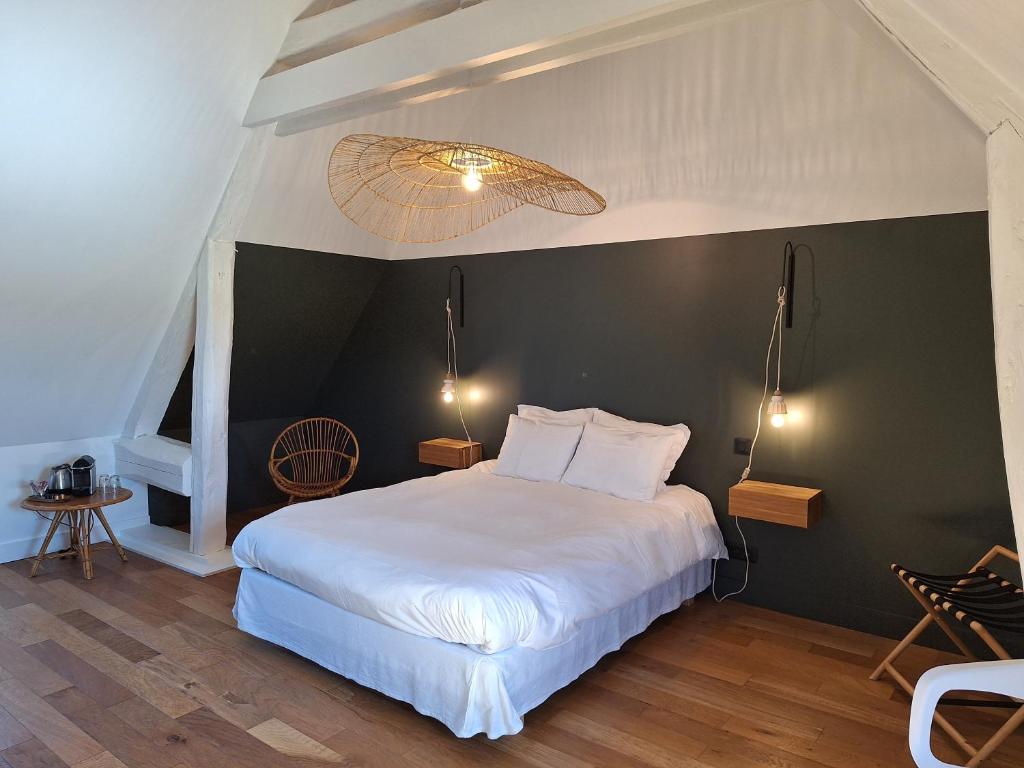 a bedroom with a white bed and a black wall at La Grange in Savonnières
