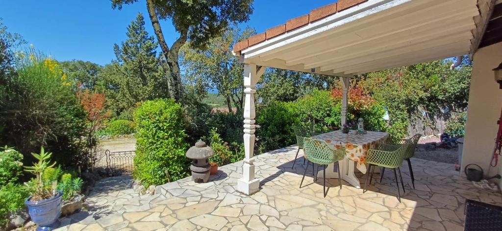 a patio with a table and chairs under a pavilion at Les 4 mousquetaires in Méjannes-le-Clap