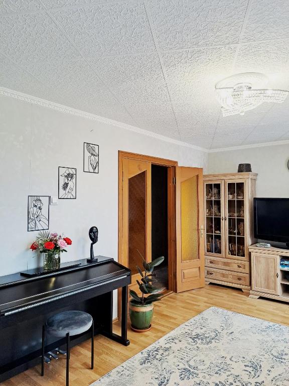 a living room with a piano and a television at DREAMSVILLE in Ventspils