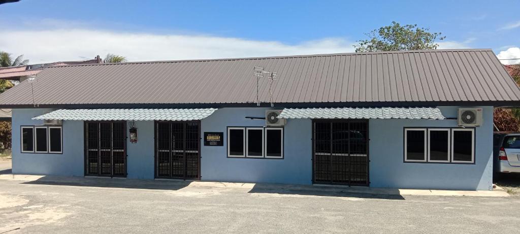 a blue building with black doors in a parking lot at Homestay Masjid Seberang Marang in Marang