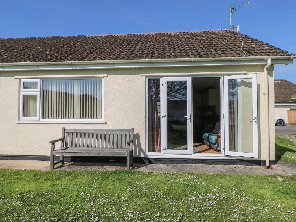 a bench sitting in front of a house at Kites - 52 Gower Holiday Village in Swansea