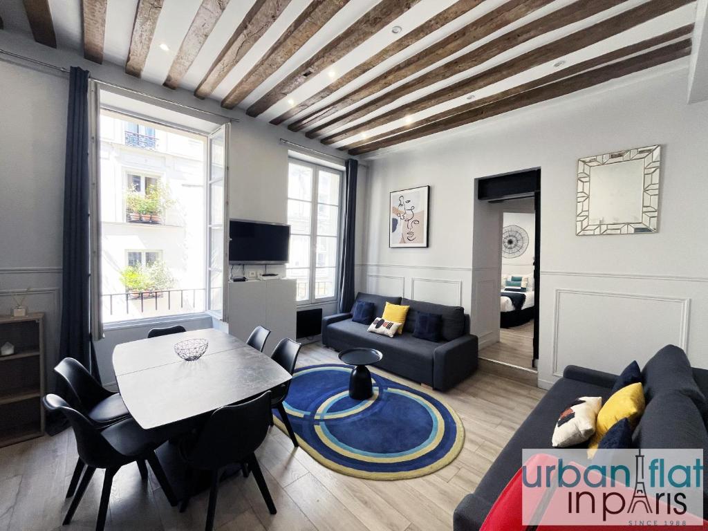 un salon avec un canapé et une table dans l'établissement Urban Flat 44 - Charming 2 Bedrooms in the center, à Paris
