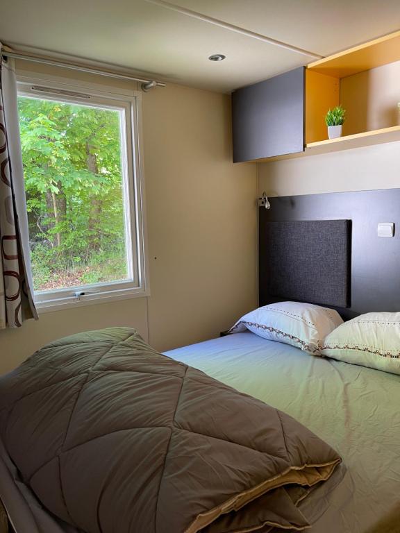 une chambre avec un grand lit avec une fenêtre dans l'établissement Camping L Eden Road, à Castellane