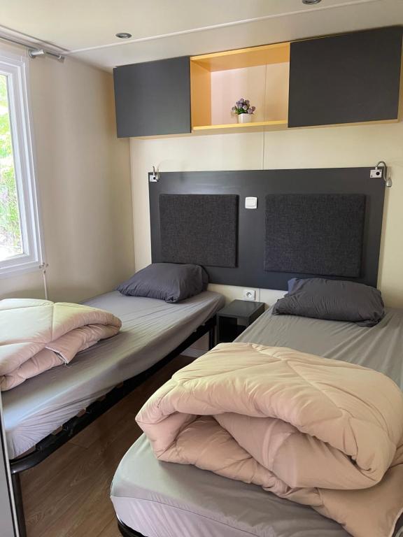 une chambre avec deux lits dans une chambre dans l'établissement Camping L Eden Road, à Castellane 65 autres photos