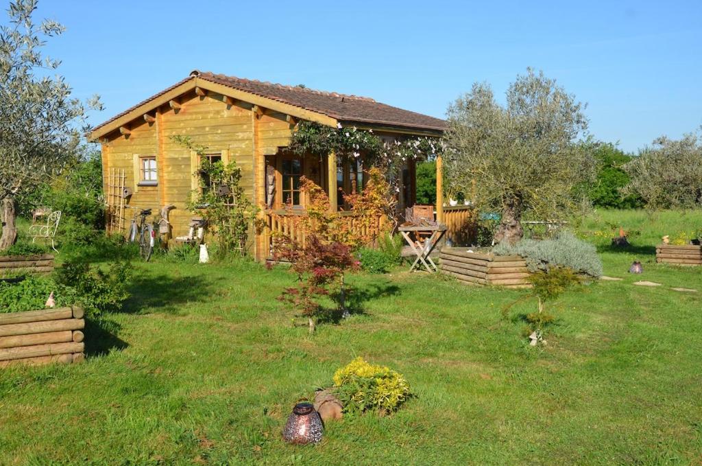 a log cabin in a yard with a yard at chalet bois pleine campagne à Pontigny in Pontigny