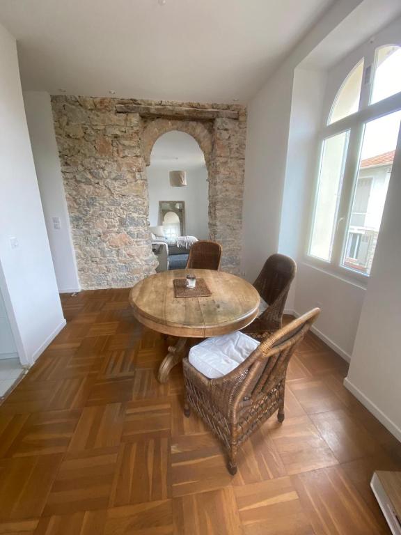 une salle à manger avec une table et des chaises en bois dans l'établissement Lisa Appartement de charme, à Cannes