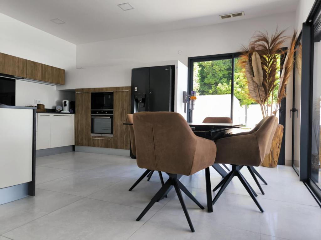 une cuisine avec une table et des chaises dans une pièce dans l'établissement Villa moderne climatisée, piscine billard jacuzzi, à Avignon