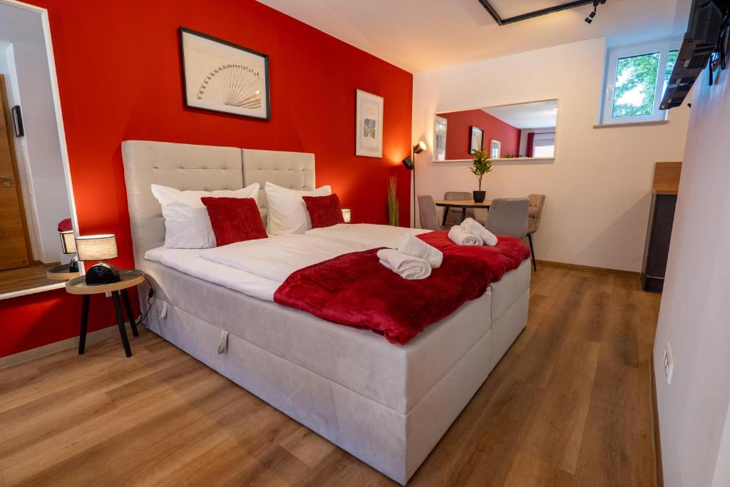 Un dormitorio con una cama grande con paredes rojas. en Mihalca Studio Apartments, en Günzburg