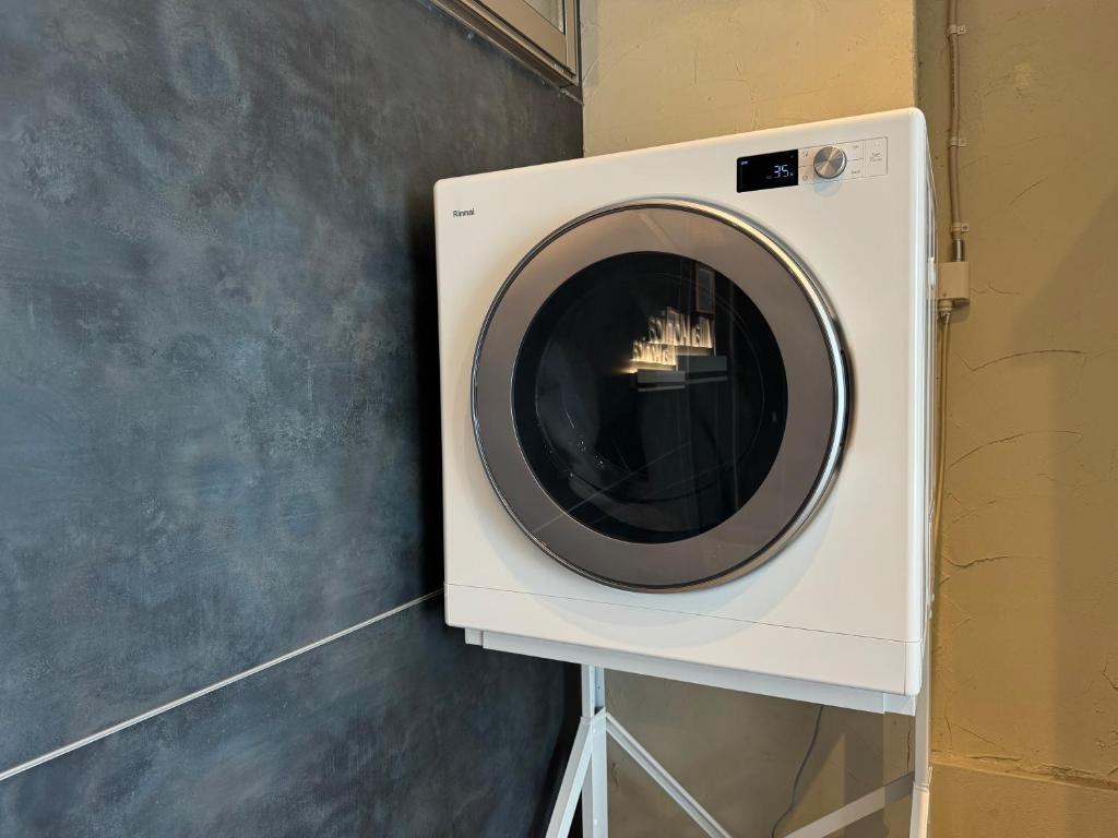 a washing machine with a mirror on the wall at Villa Monica in Nagoya