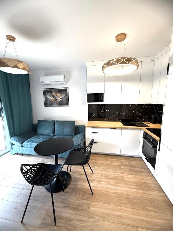a kitchen and a living room with a table and chairs at LOFT APARTAMENT III NAMYSŁÓw in Namysłów